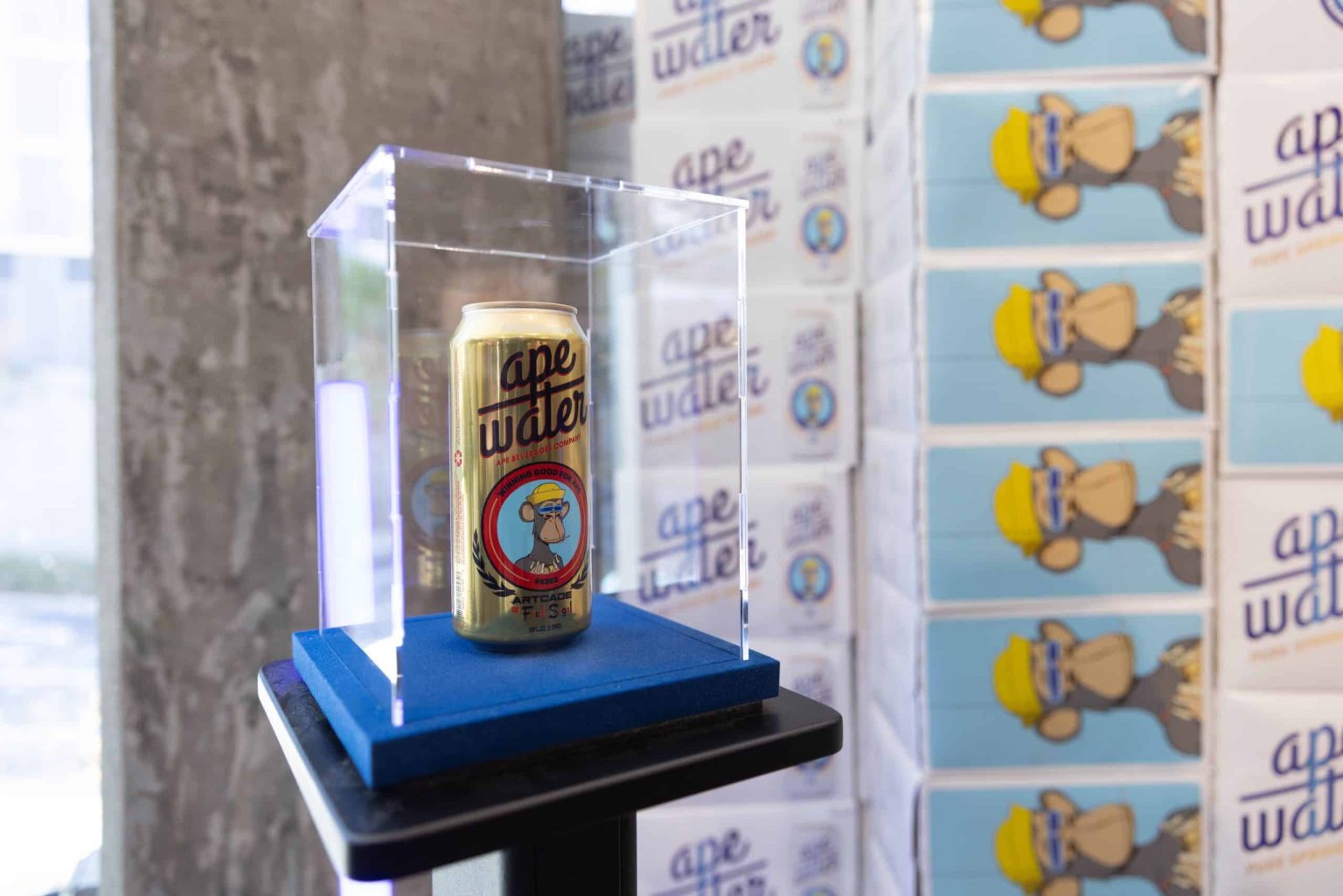 ‘APE Water’ Beverage Launches at Metaverse Boutique ARTCADE Ape Water in a gold can with glass surrounding it