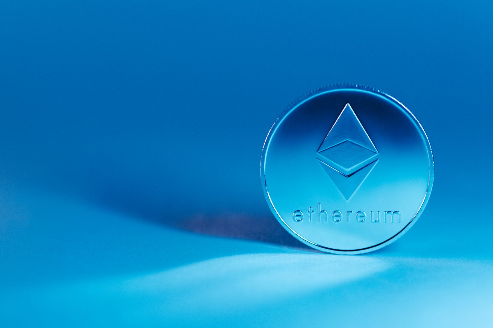 Silver Ethereum coin on a blue background, the network CryptoKitties runs on