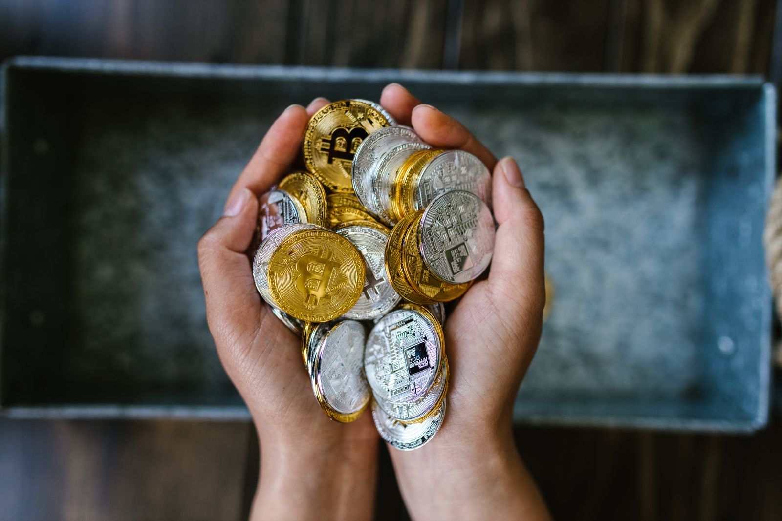 Hands holding crypto coins, illustrating GameFi token rewards